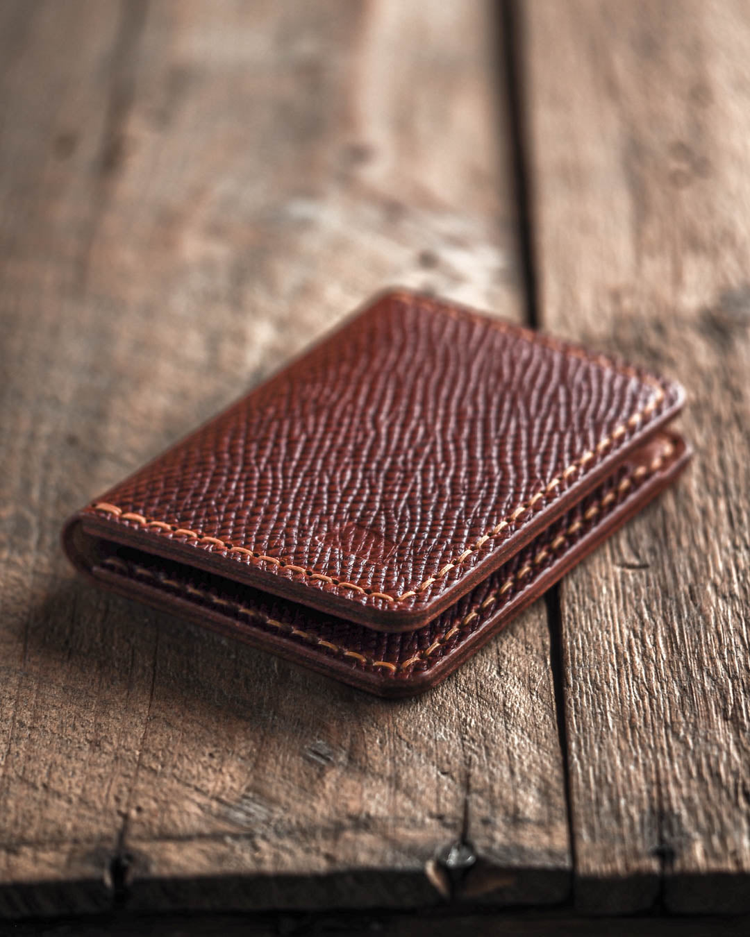 Brown leather wallet on a wooden surface