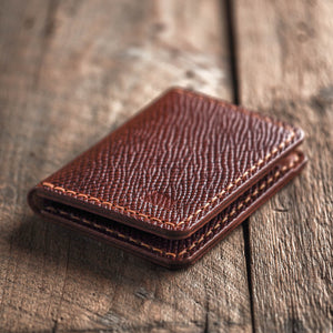 Brown leather wallet on a wooden surface