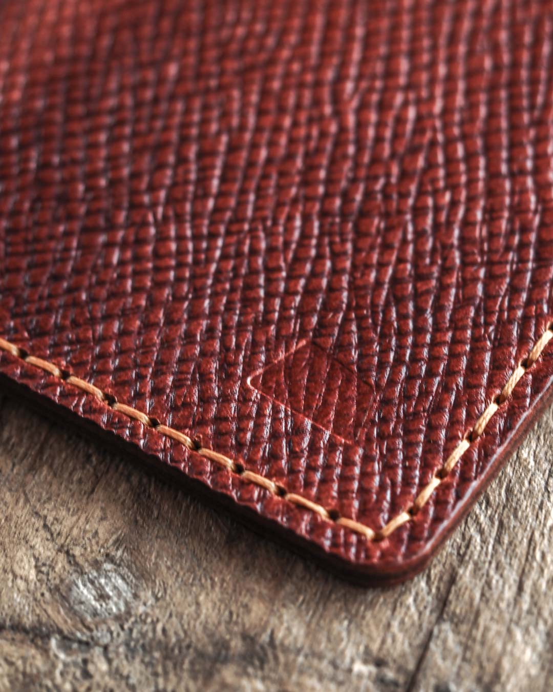 Close-up of a brown leather wallet with visible stitching and a logo