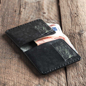 Handmade leather bi-fold wallet for men. Minimalist and rugged style. Traveler's wallet black open in use