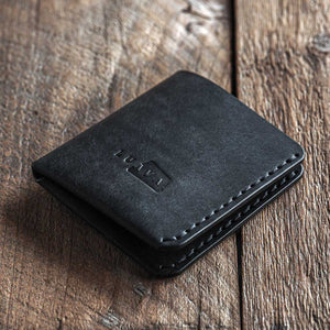 Handmade leather bi-fold wallet for men. Minimalist and rugged style. Traveler's wallet black front