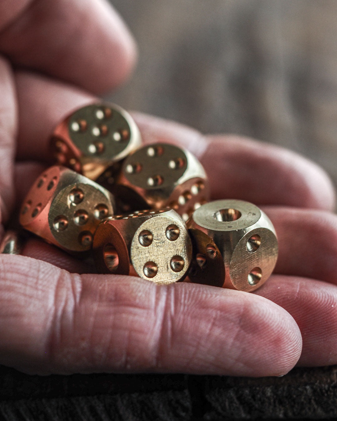 Solid brass dice set of 5 in hand
