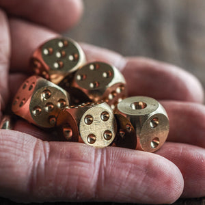 Solid brass dice set of 5 in hand
