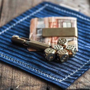 Solid brass dice set of 5 with brass pen and brass money clip on a Kanto Goods EDC hank